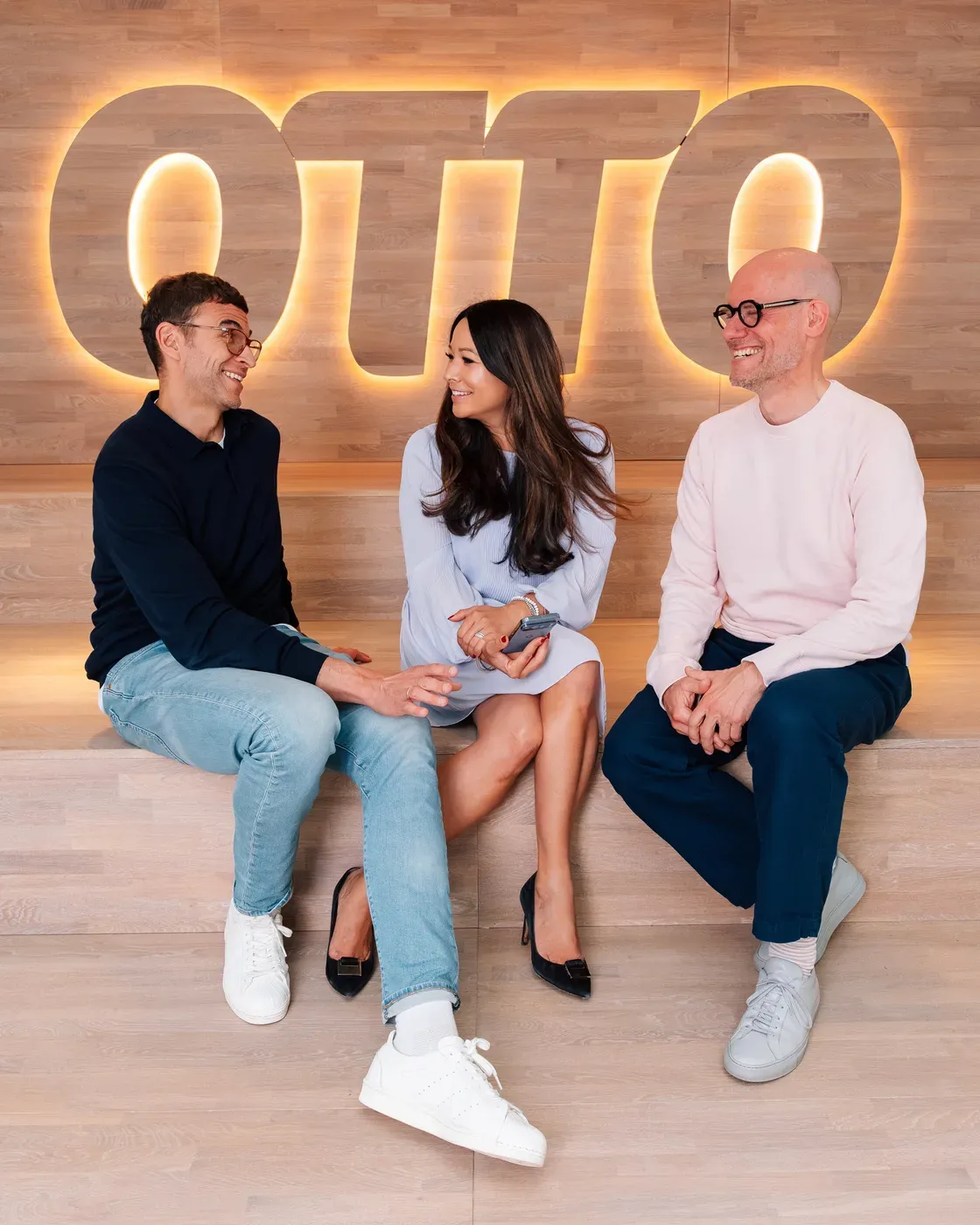 Yasmin Weiß mit zwei Gesprächspartnern vor dem OTTO-Logo