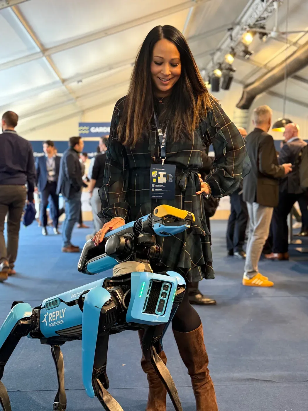 Yasmin Weiß mit einem Roboterhund auf einer Tech-Konferenz